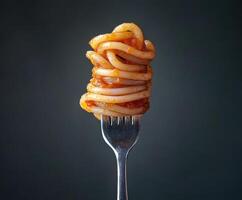 Twisted spaghetti on a fork with rich tomato sauce against a dark background photo