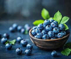 Bowl of fresh blueberries surrounded by scattered berries on a dark surface photo