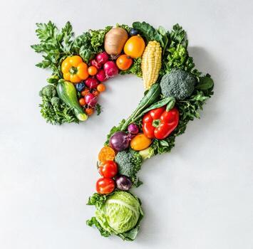 Colorful arrangement of fresh vegetables forming a question mark on a light background photo