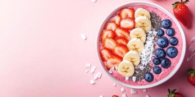 Vibrant smoothie bowl with fresh fruits and toppings on pink background photo