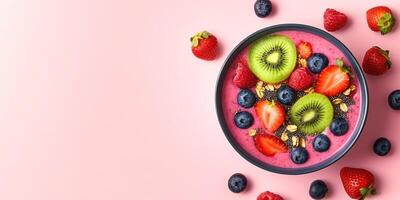 Vibrant smoothie bowl with fresh berries, kiwi, and granola on pink background. Perfect for healthy eating inspiration photo