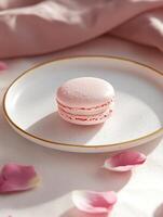 Minimalistic dessert presentation. Pink macaron on elegant plate with rose petals photo