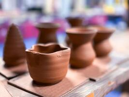 Handmade clay vessels on display in pottery workshop photo