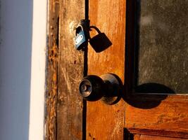 Wooden front door in a rustic wooden cottage. Rustic wooden cottage with locking door. photo