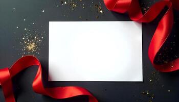 a blank sheet of paper and red ribbon on a black background photo