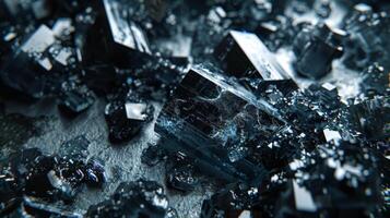 Dark mineral crystals are scattered across a textured surface, catching light in unique ways and showcasing their geometric shapes and color variations. photo