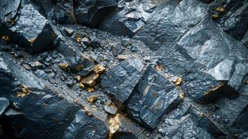 Gold veins thread through dark rock formations at a mining site, highlighting the geological wealth. The contrast in colors emphasizes the potential for valuable extraction of resources. photo
