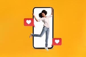 A person joyfully interacts with a smartphone, surrounded by symbols of love and communication. This vibrant setting showcases modern dating and social media connections. photo