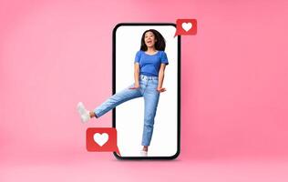 In a vibrant, pink backdrop, a joyful person engages with their smartphone, expressing happiness and love. The phone displays heart symbols, symbolizing social media connections and interaction. photo