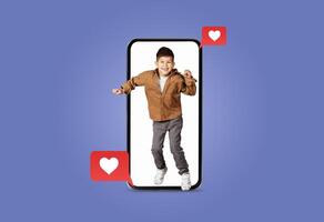 A young child joyfully dances inside a smartphone screen surrounded by heart icons. The vibrant setting showcases enthusiasm and connection through technology, perfect for Valentines Day. photo