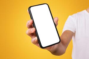 Mobile Application Ad. Close Up Of Man Showing Smart Phone Empty Screen Recommending App Standing On Yellow Orange Studio Background. Isolated Transparent Cellphone Display Mock Up, Check This Website photo