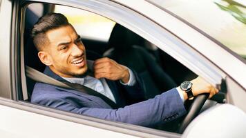 Nervous middle-eastern man in suit going to airport or important business meeting by auto, looking at road and touching his shirt, stuck in traffic, feeling stressed, side view, copy space photo
