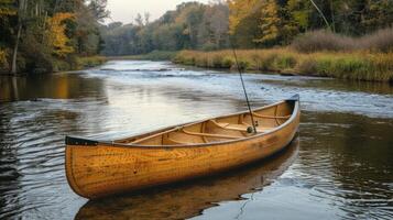 A beautifully crafted wooden canoe drifts gently on a calm river. Surrounded by colorful autumn trees, the tranquil setting reveals the serenity of nature during the early morning hours. photo
