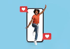 A person joyfully jumps out of a smartphone, surrounded by heart icons, embodying the excitement of connecting with others through social media and dating applications. photo