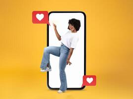 A person joyfully interacts with a smartphone, smiling while engaging with heart-themed social media messages. photo
