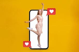 A young woman joyfully poses while emerging from a smartphone displaying heart icons and messages. This highlights the excitement of modern communication and relationships. photo