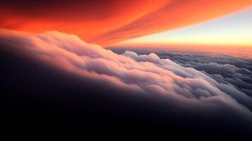 A breathtaking aerial view of vibrant orange and pink clouds at sunset above a serene horizon photo