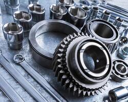 Close-up view of various metal tools and mechanical parts arranged on workbench at a workshop during afternoon photo