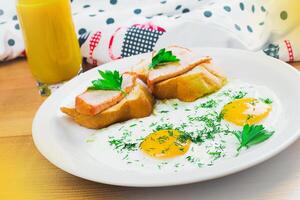 Breakfast featuring eggs and toast topped with herbs served with a refreshing beverage in a cozy kitchen setting photo