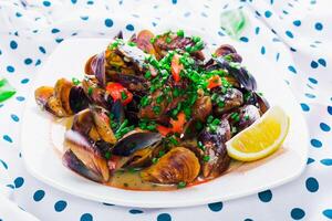 Freshly cooked shellfish garnished with vegetables and lemon in a vibrant setting photo