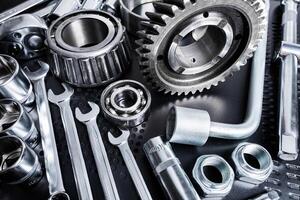 Tools and mechanical components arranged on a black surface with dramatic lighting highlighting the details photo