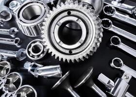 Collection of metallic tools and mechanical components arranged on a black surface showcasing craftsmanship and precision photo