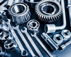 Collection of various metallic tools and components displayed on a workbench in a workshop setting photo