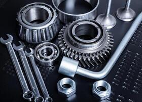 Collection of mechanical tools and parts arranged on a dark surface showcasing craftsmanship and precision tools for automotive work photo