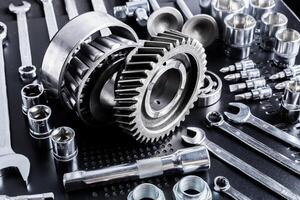 Various metallic tools and mechanical parts arranged on a dark surface showcasing craftsmanship and engineering precision photo