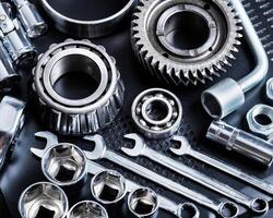 Collection of metallic tools and components arranged on a dark surface for mechanical work or engineering purposes photo
