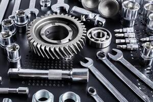 Collection of various metal tools arranged neatly on a black surface in a workshop for mechanical tasks photo