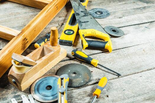 Tools laid out on a wooden surface in a workshop preparing for a DIY project on a sunny afternoon photo