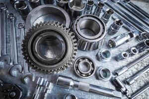 Metal tools and parts arranged on a workbench for mechanical repairs in a garage setting photo