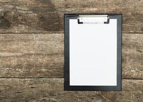 Blank clipboard on rustic wooden table ready for notes or sketches during creative brainstorming session in natural light photo