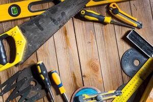 Essential hand tools arranged on a wooden workshop table for home repair and DIY projects photo