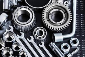 Mechanical tools and parts arranged neatly on a dark surface for repair activities and projects photo