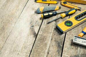 Home improvement tools are scattered on a wooden workbench ready for a project during a sunny afternoon photo