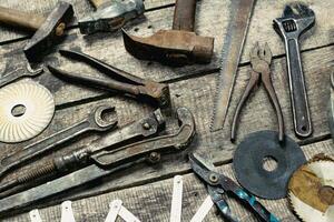 Assorted hand tools displayed on rustic wooden surface in workshop setting during daylight hours photo