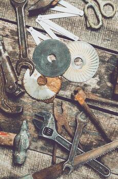 Collection of vintage hand tools and materials arranged on a rustic wooden workbench in a workshop setting photo