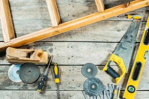 Tools organized on wooden surface with ladder for home improvement project in bright workshop during daytime photo