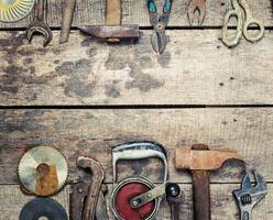 Tools and equipment arranged on a rustic wooden surface in a workshop setting photo