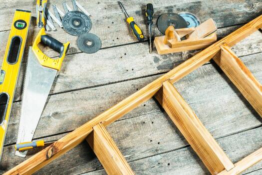 Tools and materials arranged on a wooden surface for a construction or DIY project in a cozy workshop setting photo