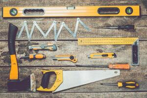 Essential tools laid out on a wooden surface for a home repair project in a workshop setting photo