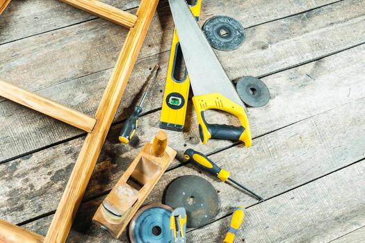 Tools scattered on rustic wooden floor during woodworking project in a workshop environment photo
