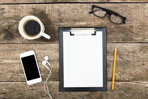 Workspace setup with coffee, notepad, smartphone, and glasses for productive planning and creativity photo