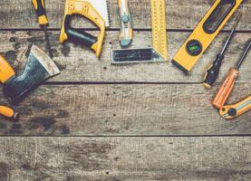 Various hand tools arranged on a rustic wooden surface ready for DIY projects and repairs photo