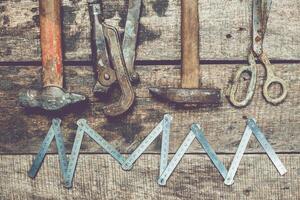 Tools arranged on a wooden surface showing craftsmanship and manual work in a rustic workshop setting photo