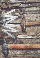 Collection of vintage tools arranged on a rustic wooden surface showcasing craftsmanship and history in an indoor workshop setting photo