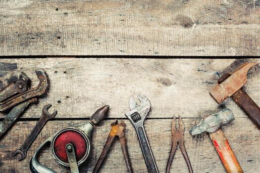 Hand tools arranged on a rustic wooden surface showcasing various shapes and sizes for home improvement tasks photo