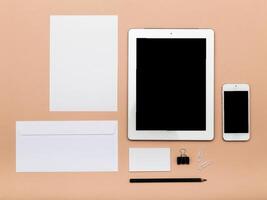 Workspace arrangement with blank documents and digital devices on a neutral background photo